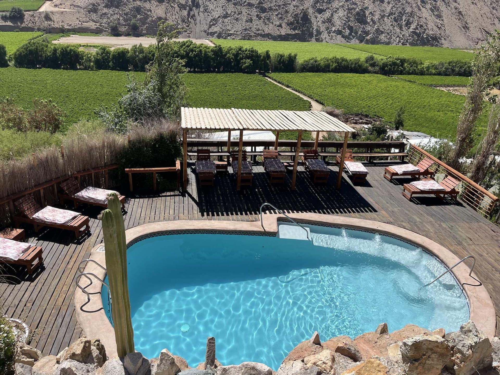 Piscina de agua salada de Cabañas Elquimista con el Valle del Elqui y sus cerros al fondo